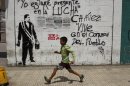 A child runs past a wall with a stencil graffiti of Venezuela's late President Hugo Chavez and spray-painted writing that reads in Spanish; "I will be present in the fight. Chavez lives in the heart of the people," in Caracas, Venezuela, Thursday, March 7, 2013. Battling an unspecified cancer, Chavez died Tuesday. His body was taken to the military academy Wednesday, where he started his army career, his flag-draped coffin lying in state as a mile-long line of mourners came to pay homage Thursday. (AP Photo/Esteban Felix)