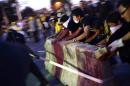 Anti-government protesters tear down barricades during a demonstration outside Government House in Bangkok