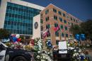 Two squad cars parked outside the Dallas Police Headquarters serve as memorials for victims of the sniper shooting on July 8, 2016
