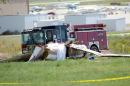 Personal de bomberos trabaja en el lugar donde murieron tres personas en un accidente de avioneta en un terreno al noroeste de la pista principal del Aeropuerto Municipal de Erie, Colorado, el domingo 31 de agosto de 2014. (Foto AP/The Daily Camera, Cliff Grassmick)