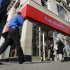 People pass a Bank of America brach, in New York,  Monday, Jan. 7, 2013. Bank of America will pay $10.3 billion to the government mortgage agency Fannie Mae to settle claims resulting from mortgage-backed investments that soured during the housing crash.  (AP Photo/Richard Drew)