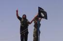 An image made available by jihadist Twitter account Al-Baraka news on June 11, 2014 allegedly shows Islamic State militants hanging their flag near the Syrian-Iraqi border
