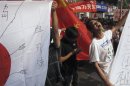 Anti-Japan protesters chants slogans beside a defaced Japanese flag in Guangzhou