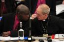 Justin Welby, the Archbishop of Canterbury (R) speaks with John Sentamu, the Archbishop of York, during the third and final day of the Church of England General Synod in central London on November 20, 2013