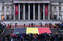 People gather near a giant Belgian flag during a tribute to the victims of the Brussels terror attacks, outside if The Naional Gallery in Trafalgar Square in central London on March 24, 2016