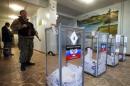 A pro-Russian separatist stands guard during the self-proclaimed Donetsk People's Republic leadership and local parliamentary elections at a polling station in the settlement of Telmanovo