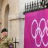 A soldier stands guard next to an Olympic banner in London on Wednesday