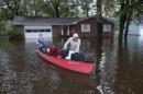 Greg Rodermond and Mandy Barnhill use a canoe to evacuate from Mandy's home on Long Avenue in Conway