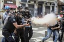 Police fire tear gas as riot police spray a water canon at demonstrators who remained defiant after authorities evicted activists from an Istanbul park, making clear they are taking a hardline stand against attempts to rekindle protests that have shaken the country, near city's main Taksim Square in Istanbul, Turkey, Sunday, June 16, 2013. (AP Photo )