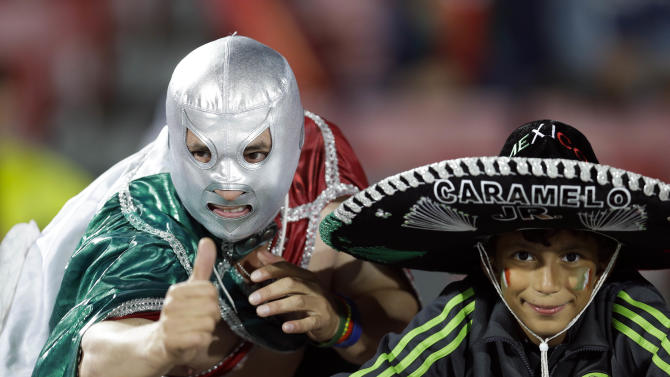 Mexican fans, one wearing a Mexican wrestling mask, sit before the start of a Copa America Group A soccer match between Chile and Mexico at El Nacional stadium in Santiago, Chile, Monday, June 15, 2015. (AP Photo/Natacha Pisarenko)