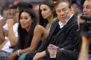 In this photo taken on Friday, Oct. 25, 2013, Los Angeles Clippers owner Donald Sterling, right, and V. Stiviano, left, watch the Clippers play the Sacramento Kings during the first half of an NBA basketball game in Los Angeles. The NBA is investigating a report of an audio recording in which a man purported to be Sterling makes racist remarks while speaking to Stiviano. NBA spokesman Mike Bass said in a statement Saturday, April 26, 2014, that the league is in the process of authenticating the validity of the recording posted on TMZ's website. Bass called the comments "disturbing and offensive." (AP Photo/Mark J. Terrill)