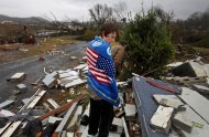 Will Carter, 15, wraps himself up in a towel he found while searching debris for the family dog, a pit bull named Niko, upon arriving to his damaged home from school following a tornado, Wednesday, Jan. 30, 2013, in Adairsville, Ga. A fierce storm system that roared across Georgia has left at least one person dead after it demolished buildings and flipped vehicles on Interstate 75 northwest of Atlanta. (AP Photo/David Goldman)