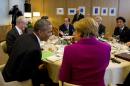 US President Barack Obama (L) speaking to Germany's Chancellor Angela Merkel during a working dinner at the G7 summit in Brussels, on June 4, 2014
