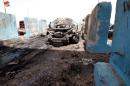 A destroyed vehicle is seen at the site of a suicide bomb attack at a checkpoint in Rashidiya, a district north of Baghdad
