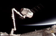 This image provided by NASA-TV shows the SpaceX Dragon commercial cargo craft, top, after Dragon was grappled by the Canadarm2 robotic arm and connected to the International Space Station, Friday, May 25, 2012. Dragon is scheduled to spend about a week docked with the station before returning to Earth on May 31 for retrieval. (AP Photo/NASA)