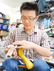 　年僅31歲的7年級生王文楷，自15歲學習修鞋已15年，成為台中最年輕、承包中部百貨鞋品維修的師傅。（梁貽婷攝）