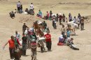AP10ThingsToSee - FILE - Syrian refugees cross into Iraq at the Peshkhabour border point in Dahuk, 260 miles (430 kilometers) northwest of Baghdad, Iraq, Tuesday, Aug. 20, 2013. Around 30,000 Syrians, the vast majority of them Kurds, have fled the region over a five-day stretch and crossed the border to the self-ruled Kurdish region of northern Iraq. (AP Photo/Hadi Mizban)