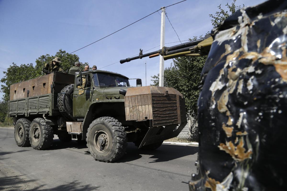 Pro-Russian rebels drive an armored truck in Donetsk, eastern Ukraine, Sunday, Sept. 7, 2014. Strong explosions were heard early Sunday on the outskirts of the main rebel-held city in eastern Ukraine near the airport, raising new fears that a cease-fire signed two days ago is on the verge of collapse. Blasts powerful enough to be heard in downtown Donetsk came from the area near the airport, which has been under the control of government troops since May and has come under unremitting attacks from pro-Russia separatist rebels since then. (AP Photo/Sergei Grits)