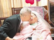 　期待吻醒妳87歲老榮民陶天恩（左）與愛妻邱雪梅結縭55年，愛妻3年前車禍變植物人，他不離不棄，25日為愛妻披白紗圓夢，並輕吻愛妻。（黃筱珮攝）