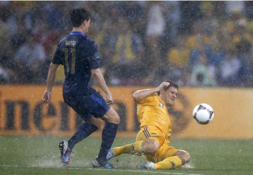 France's Nasri and Ukraine's Mikhalik fight for the ball as heavy rain pours down during their Group D Euro 2012 soccer match at the Donbass Arena in Donetsk
