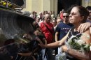 Ofelia Acevedo, wife of Oswaldo Paya, one of Cuba's best-known dissidents, mourns as the vehicle with the remains of her husband arrive at the cemetery for his burial in Havana