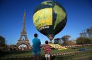 Boys look at a hot air balloon of the environmental group Greenpeace, near the Eiffel Tower ahead of the 2015 Paris Climate Conference, in Paris, Saturday, Nov. 28, 2015. The conference with more than 100 heads of state is scheduled to start on Nov.30. (AP Photo/Thibault Camus)