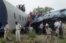 Indian officials and rescuers gather around the wreckage after the Gorakhpur Express passenger train slammed into a parked freight train Chureb, near Basti, Uttar Pradesh state,, India, Monday, May 26, 2014. According to officials dozens were killed. (AP Photo)