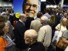 A huge picture of Berkshire Hathaway Chairman Buffett looks over shareholders swarming the exhibit floor where companies owned by Berkshire display and sell their products, in Omaha