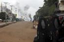 Guinea's security forces are seen as smoke billows on a street in Bambeto during a protest after opposition candidates called on Monday for the results of the election to be scrapped due to fraud, in Conakry