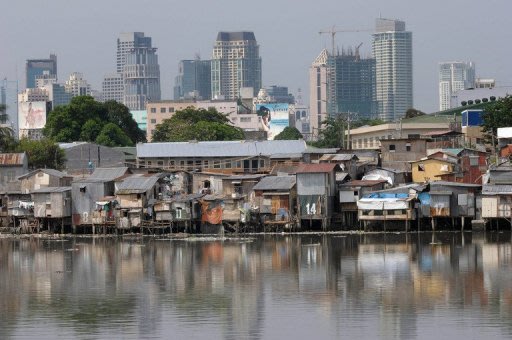 A slum area is backdropped with the Manila skyline