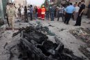 In this picture taken on Sunday, July 14, 2013, security forces inspect the scene of a car bomb attack in Basra, Iraq. Ramadan is shaping up to be the deadliest in Iraq since a bloody insurgency and rampant sectarian killings had the country teetering on the edge of civil war more than half a decade ago. (AP Photo/ Nabil al-Jurani)