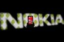 A man holding a Nokia Lumia 820 phone is seen through a Nokia logo with a background displaying Android logos on a LCD screen in the central Bosnian town of Zenica
