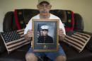 In this Saturday, July 25, 2015 photo Keith Wightman shows a frame picture of his son Lance Cpl. Brett Wightman at his home in Washington Court House, Ohio. Wightman was one of 14 Marines from Ohio-based Lima Company who were killed by an IED explosion in Iraq 10 years ago.