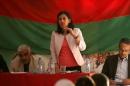 Hadiya Yousef, a Kurdish official, talks in-front of a Movement for a Democratic Society (TEV-DEM) flag during a local conference which discusses Federalism in Hasaka