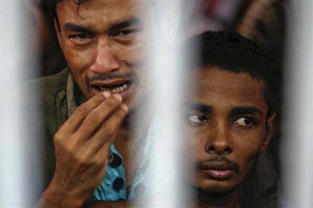 Rohingya people from Myanmar, who were rescued from human traffickers, react from inside a communal cell at Songkhla IDC