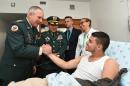 Colombia's Army Commander General Alberto Mejia (L), accompanied by Armed Forces Commander General Juan Pablo Rodriguez (C,) greets Army Lieutenant Cristian Moscoso Rivera, upon his release by FARC guerrillas, on July 19, 2015, at hospital in Bogota