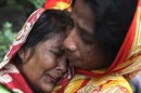 A Bangladeshi woman, left, whose relative died in a landslide is consoled by another on the outskirts of Chittagong, Bangladesh, Wednesday, June 27, 2012. Rescuers said landslides caused by heavy monsoon rains have killed at least 30 people in southern Bangladesh. (AP Photo/Anrup Titu)