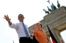 US President Barack Obama, left, waves to invited guests next to German Chancellor Angela Merkel . right, in front of Brandenburg Gate at Pariser Platz in Berlin, Germany Wednesday June 19, 2013. , On the second day of his visit to Germany, Obama met with German President Joachim Gauck and Chancellor Angela Merkel and delivered a speech at Brandenburg Gate. (AP Photo/Michael Kappeler,Pool)