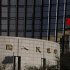 China's nation flag flies in front of the headquarters of the People's Bank of China, the central bank, in Beijing