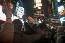 Protesters in Times Square raise their hands and chant while carrying signs in reaction to a non indictment against a police officer in the death of Eric Garner, Wednesday Dec. 3, 2014, in New York. (AP Photo/Bebeto Matthews)