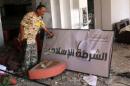 A fighter from Libyan forces allied with the U.N.-backed government displays a sign that reads "Islamic Police" in a building used as a police office by Islamic State militants in neighbourhood Number Three in Sirte