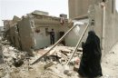 Residents inspect the site of a bomb attack in al-Wahda district of Baghdad