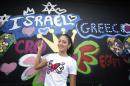 FILE - in this Sunday, Jan. 11, 2015 file photo, Miss Israel, Doron Matalon, poses for photos after she painted her country's name on a wall in Miami's Wynwood area. Explosive confrontations are nothing new for Israel and Lebanon, but the latest spat between the longtime foes is perhaps the first to have been caused by an alleged photo-bomb. A seemingly innocuous selfie at the Miss Universe pageant in Miami has sparked criticism in Lebanon because it featured a smiling Miss Lebanon alongside Miss Israel. The Israeli beauty queen, Doron Matalon, posted a picture of herself with colleagues from Japan, Slovakia and Lebanon on her Instagram account. The result? A formal Lebanese investigation into the scandal. (AP Photo/J Pat Carter, File)