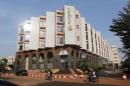 People drive motorcycles past the Radisson Blu hotel in Bamako