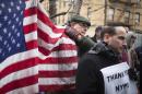 Mourners hold signs and an American flag as they gather with dozens to show support for policemen in New York