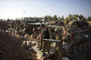 Israeli soldiers prepare APCs outside the Gaza Str &hellip;