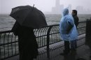 People look at waves at the New York Harbor as Hurricane Sandy approaches New York