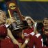 Oklahoma's Keilani Ricketts, left, holds the championship trophy after Oklahoma defeated Tennessee in the second game of the best of three Women's College World Series NCAA softball championship series in Oklahoma City, Tuesday, June 4, 2013. Oklahoma won the game 4-0 and the best of three series in two games.(AP Photo/Sue Ogrocki)