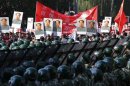 Protesters holding posters of China's late Chairman Mao Zedong, Chinese national flags and banners as soldiers and policemen stand guard during a protest on the 81st anniversary of Japan's invasion of China, outside the Japanese embassy in Beijing