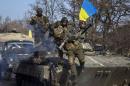Members of the Ukrainian armed forces ride on an armoured personnel carrier near Debaltseve